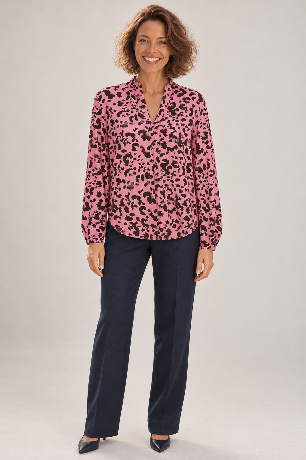 Emma wearing the Saint Tropez EDASZ pink animal print blouse with navy trousers, full-length view against a neutral studio background.