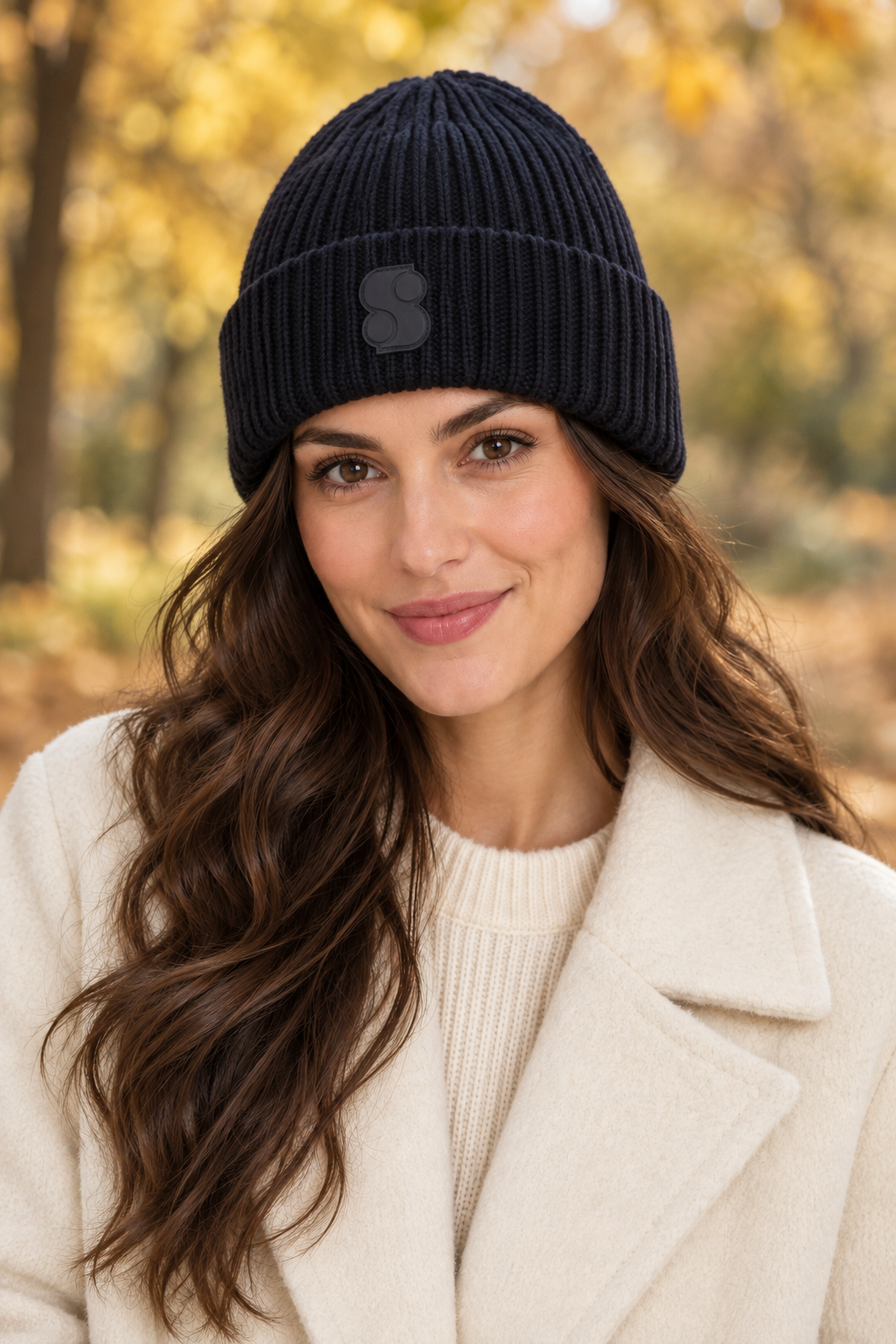 Woman wearing the s.Oliver navy ribbed beanie with tonal S patch in an autumn park