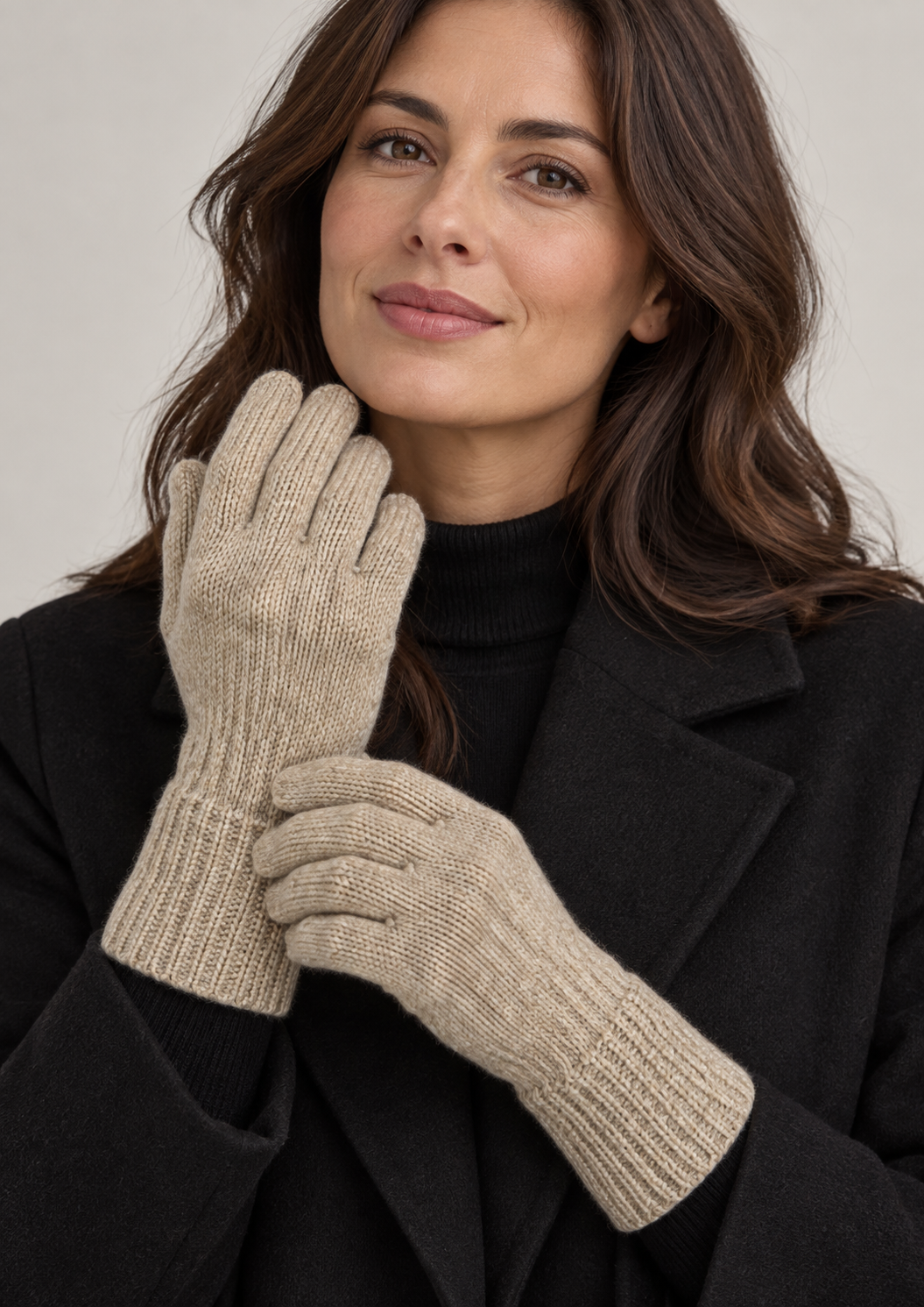 Model wearing beige melange s.Oliver knitted gloves with a black coat against a neutral studio background