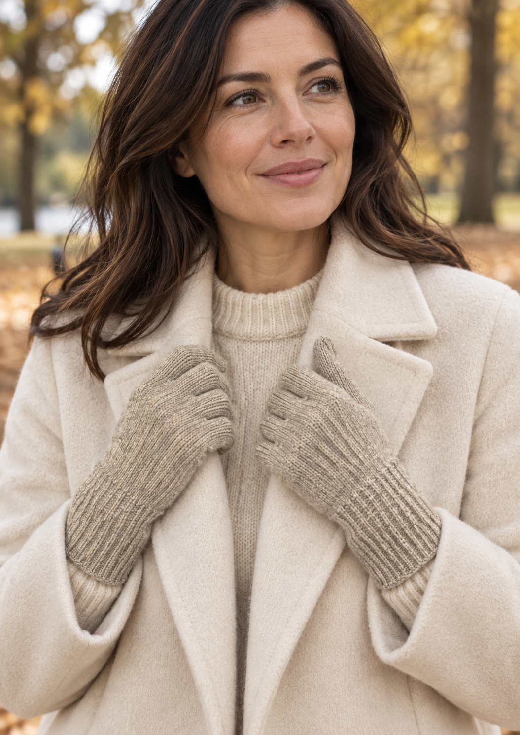 Model wearing beige melange s.Oliver knitted gloves with a cream coat in an autumn park