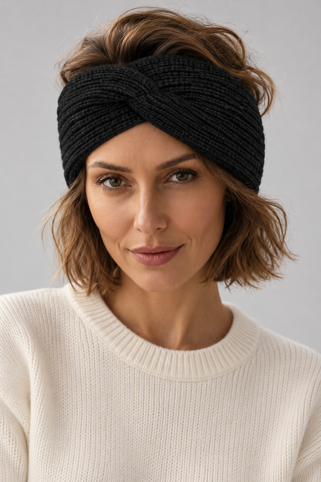 Woman wearing a black s.Oliver twist headband with a cream jumper against a neutral background