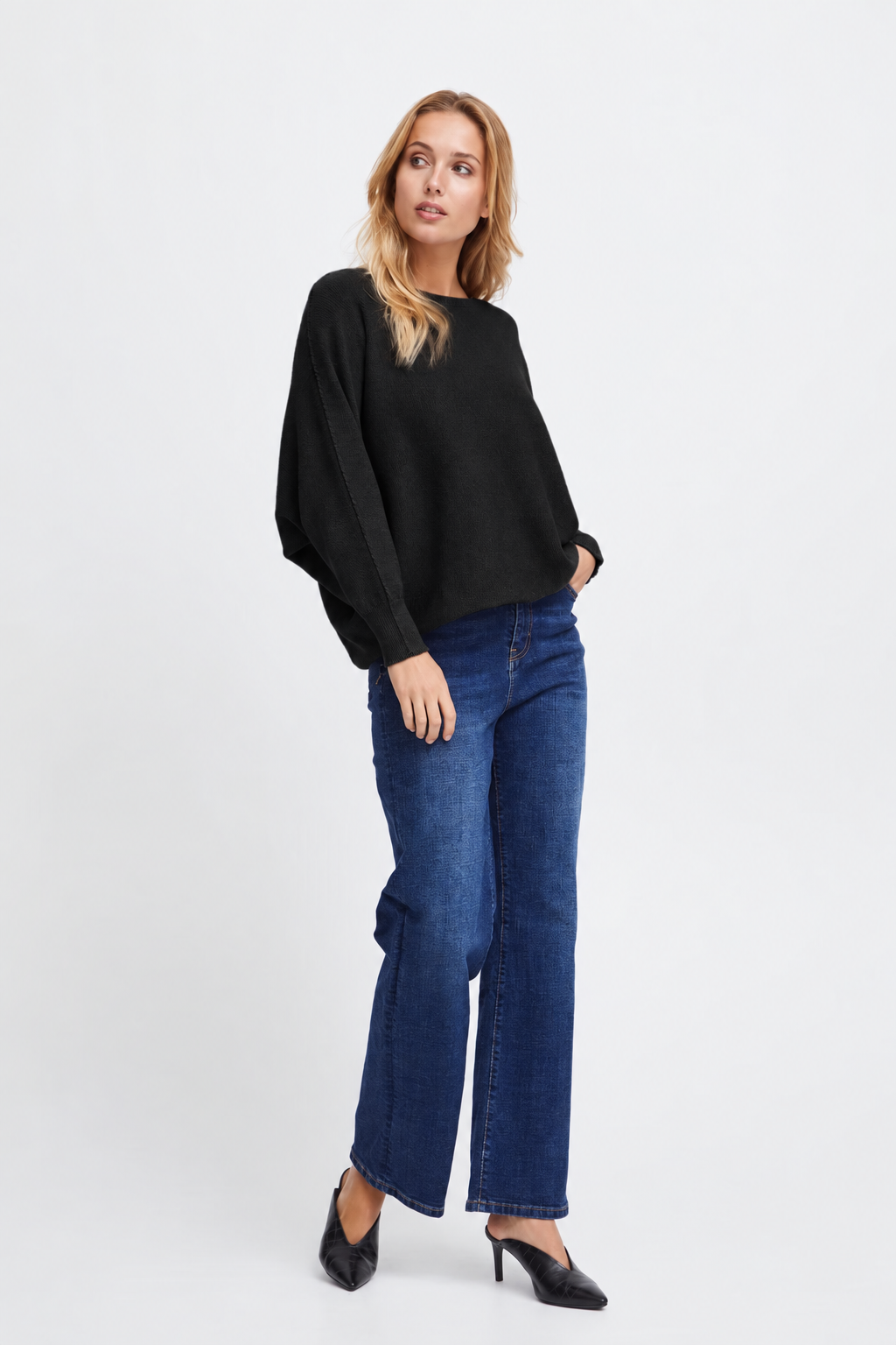 Full-length view of the Sorbet Basil black knit jumper with long sleeves, styled with blue jeans and black shoes